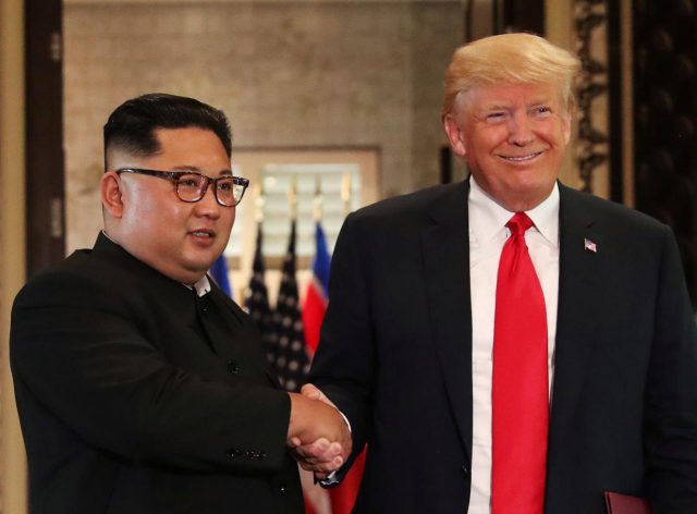 U.S. President Donald Trump and North Korea's leader Kim Jong Un shake hands after signing documents during a summit at the Capella Hotel on the resort island of Sentosa, Singapore